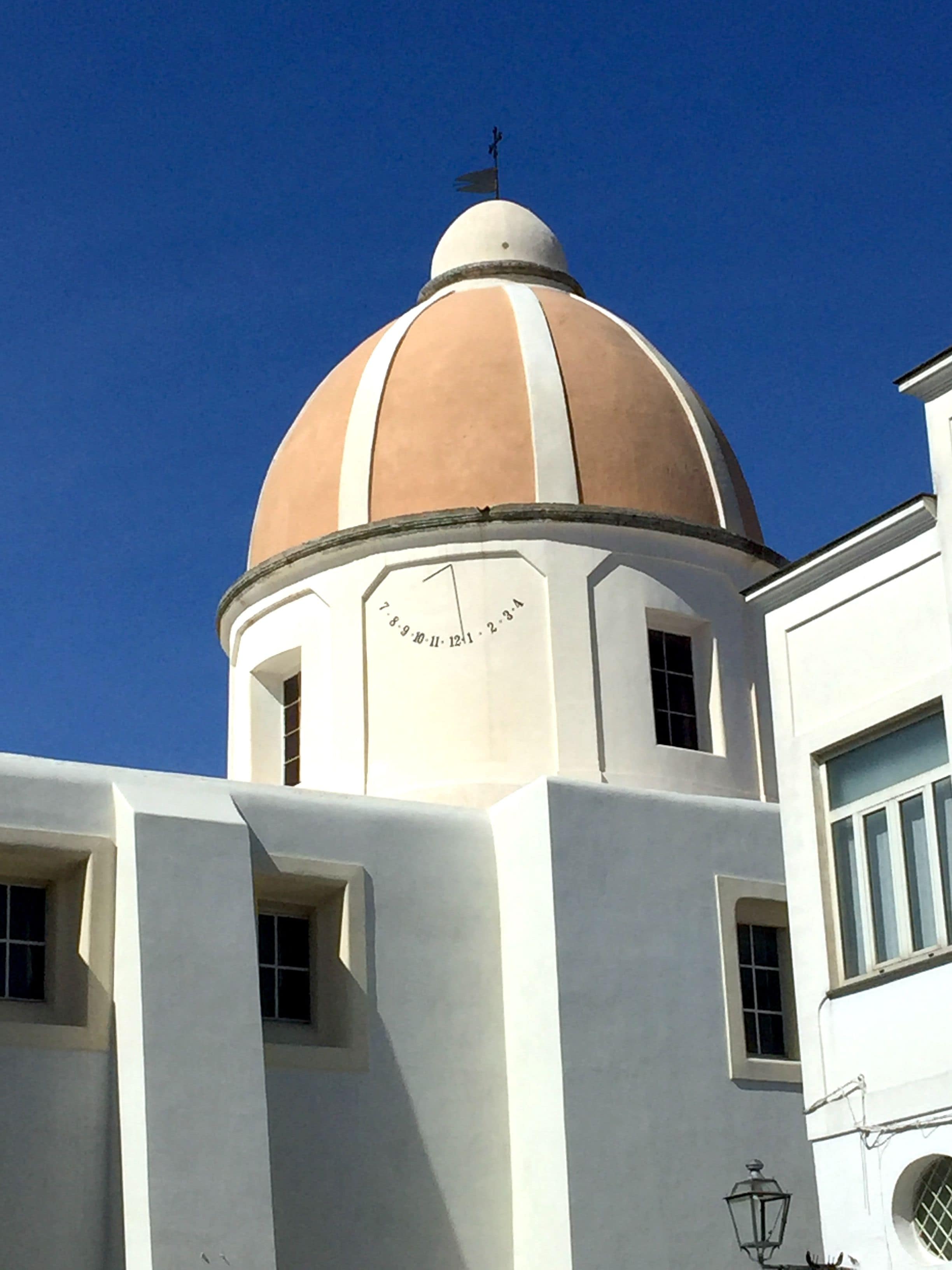 Um edifício com uma grande cúpula e um relógio na fachada.