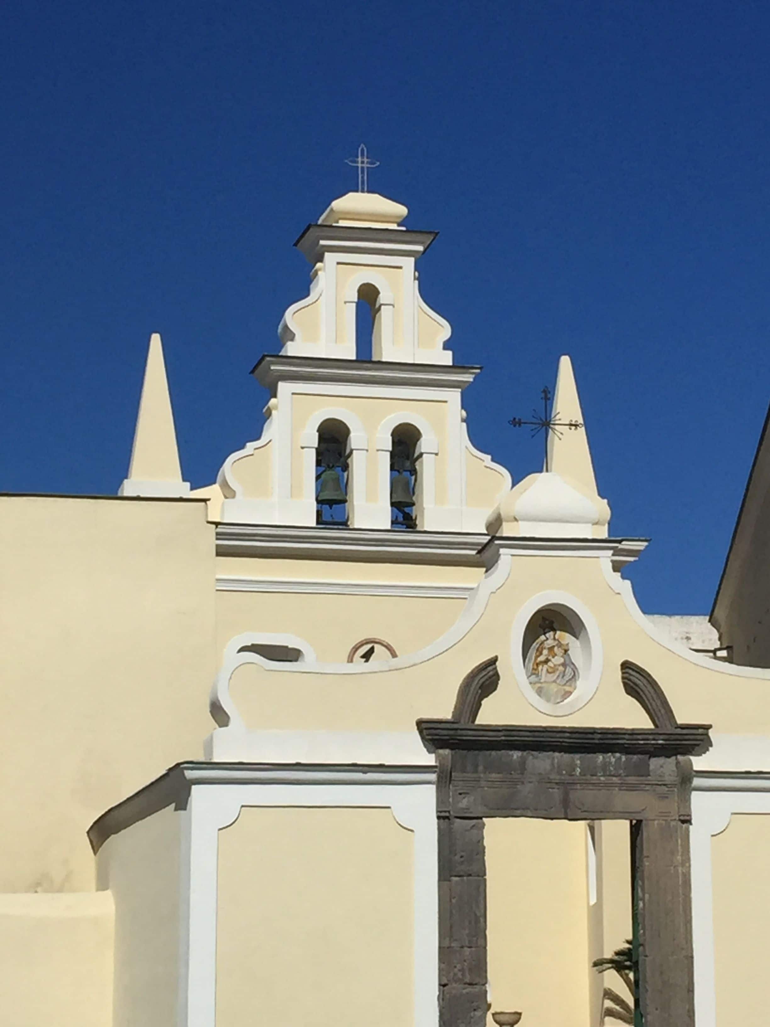 A church with a bell tower, arched windows, and a weather vane.
