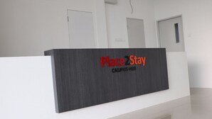 Una mesa de recepción con un cartel que dice "Place2Stay Campus Hotel".