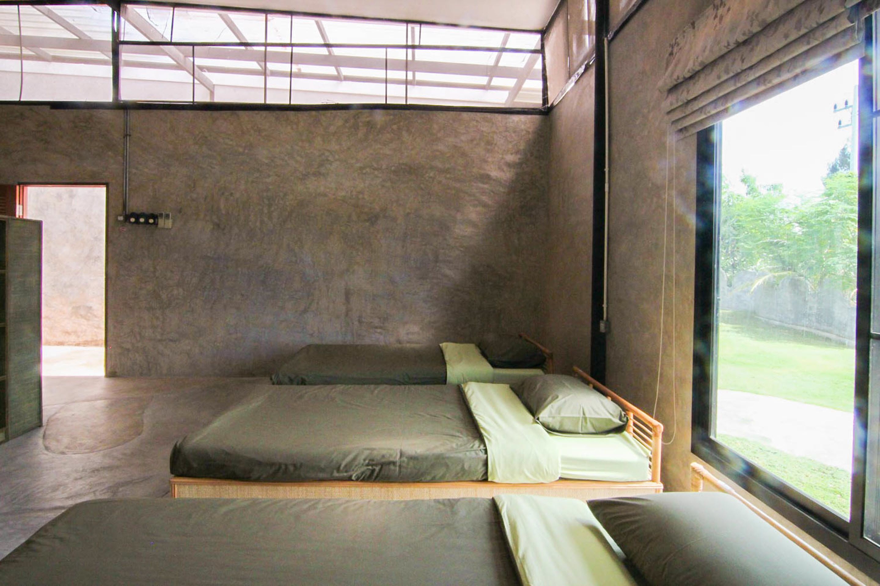 Ein modernes Zimmer mit zwei Betten, einem Oberlicht und einem großen Fenster.