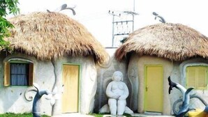 A whimsical architectural style with thatched-roof huts and a central sculpture. - Naidee Sculptured Huts (Hua Hin)