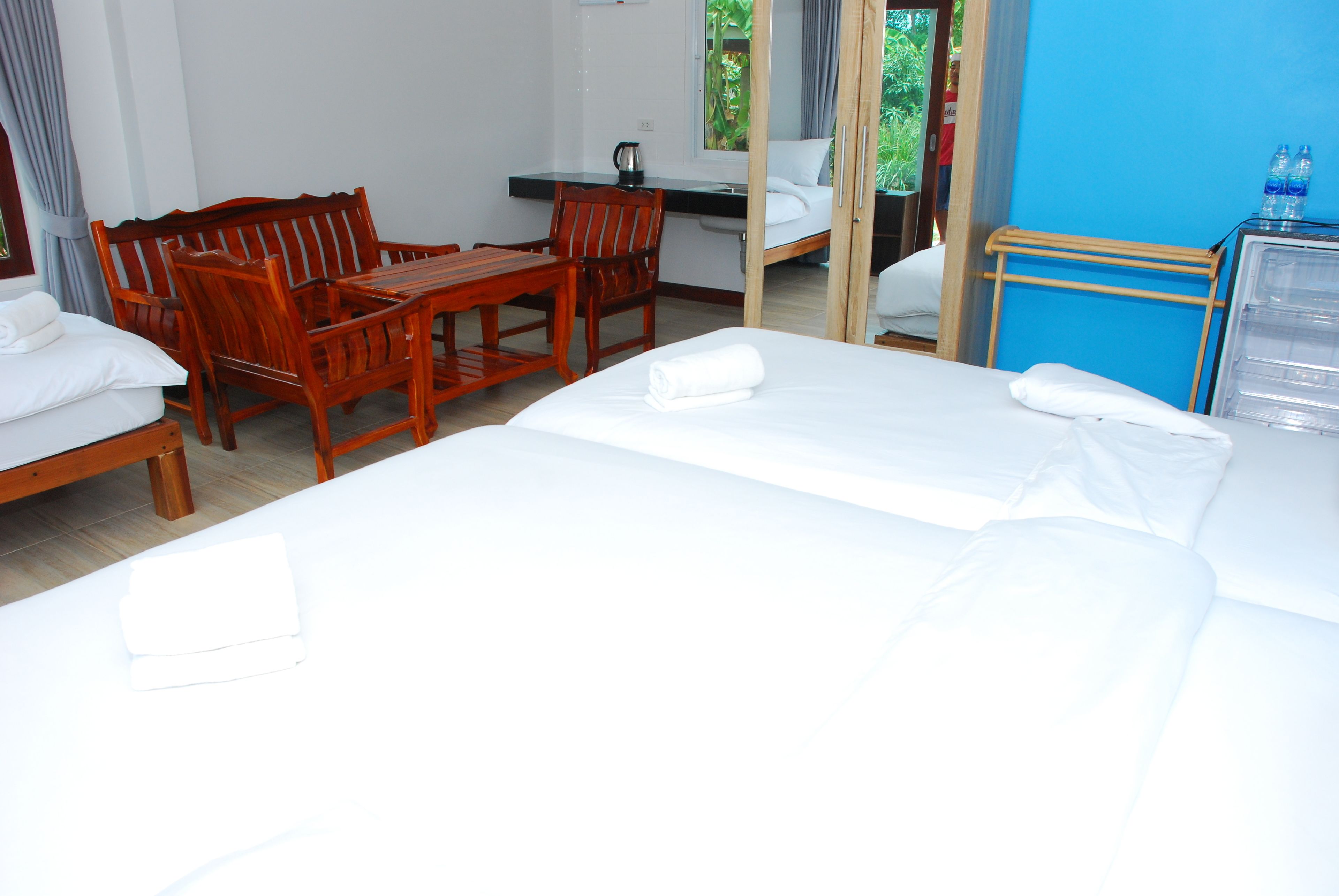 Hotellihuone, jossa on kaksi sänkyä, puinen ruokapöytä ja tuolit.