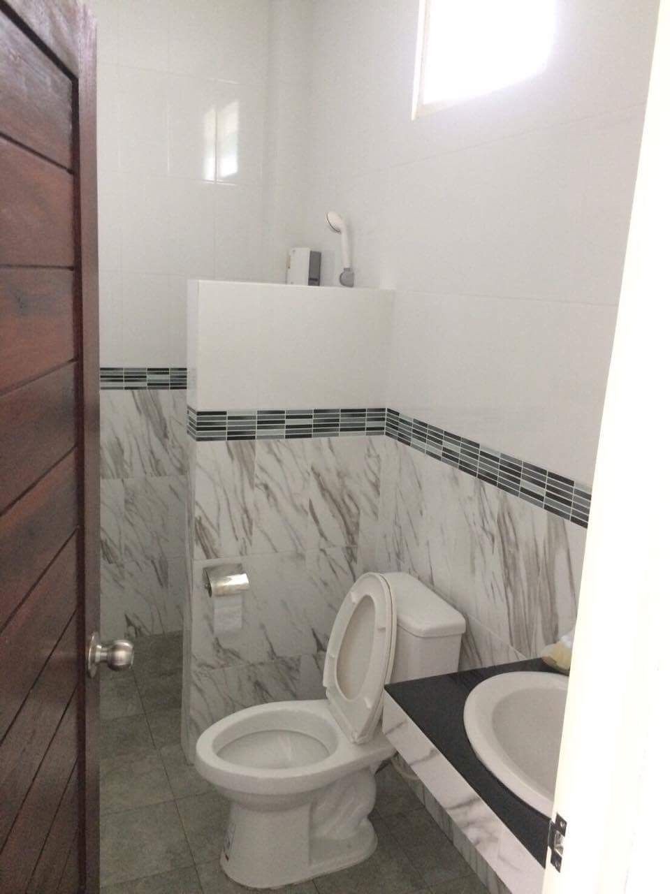 A bathroom with a toilet, sink, and a shower area.