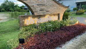 A stone archway with a sign that reads "Dusit Thani Resort". - Pran Kiang Lay (Pranburi)