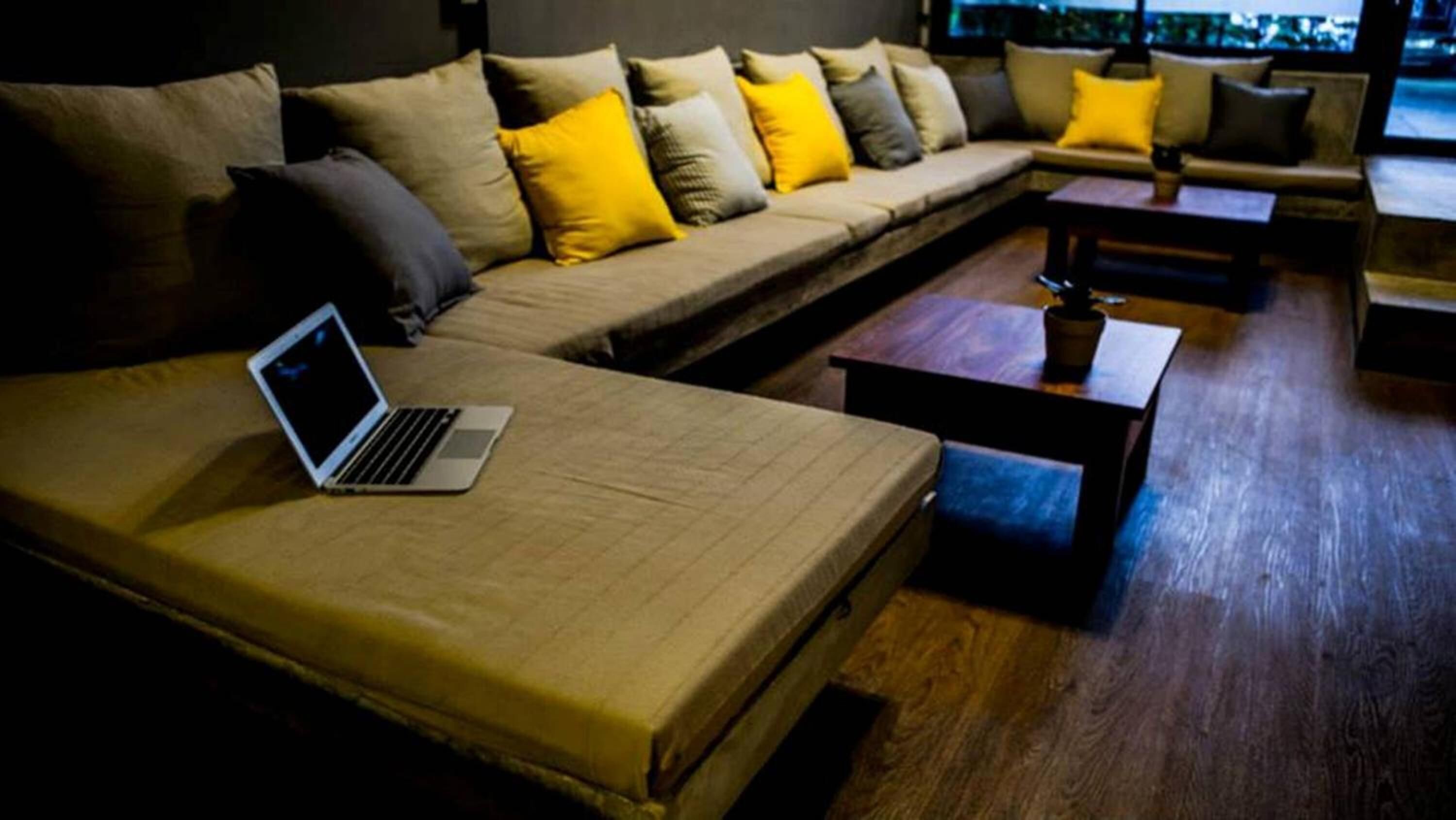Ein modernes Wohnzimmer mit einer Couch, einem Couchtisch und einem Laptop auf einem Bett.