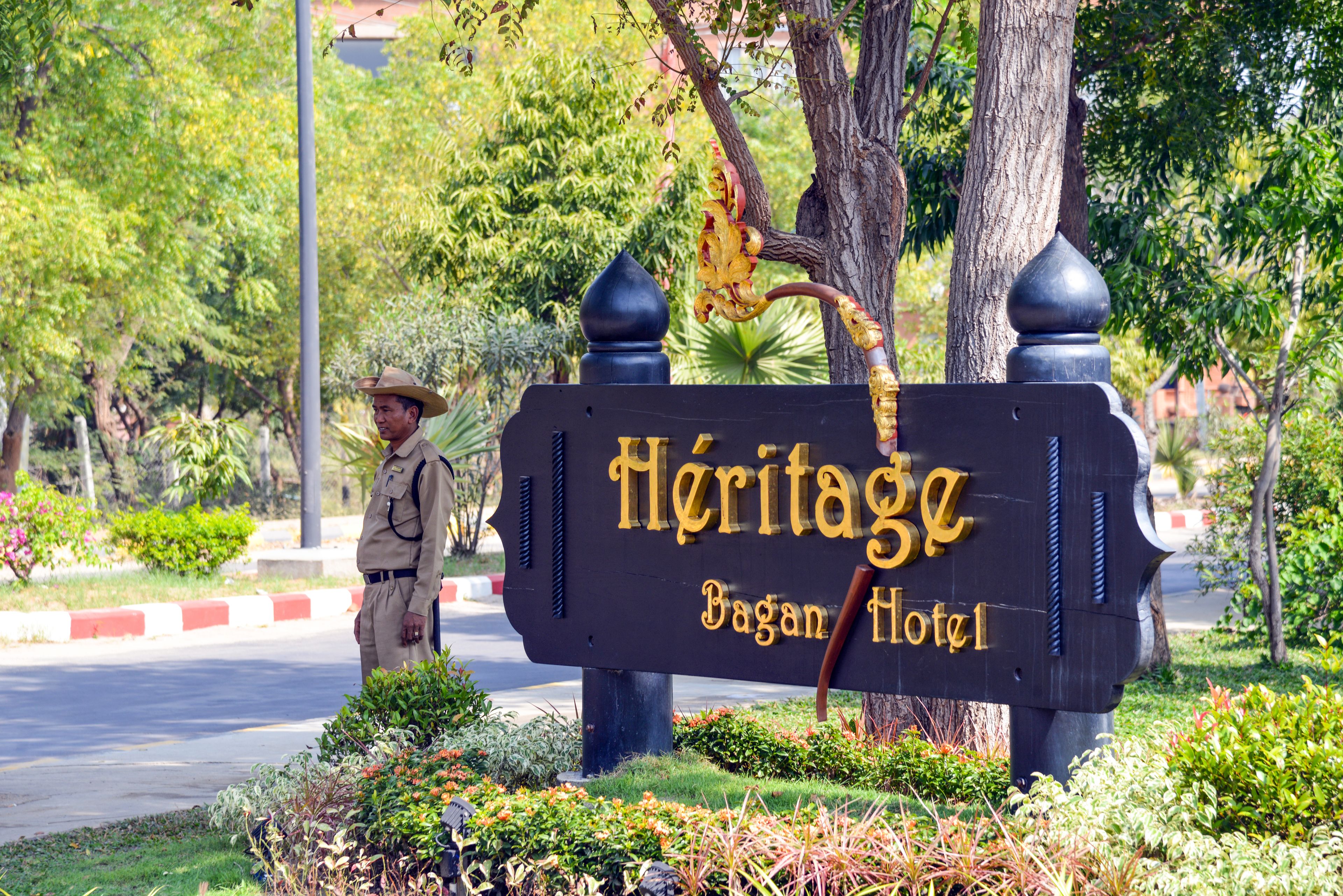 Letrero del Hotel Heritage Bagan con un guardia de seguridad a un lado.
