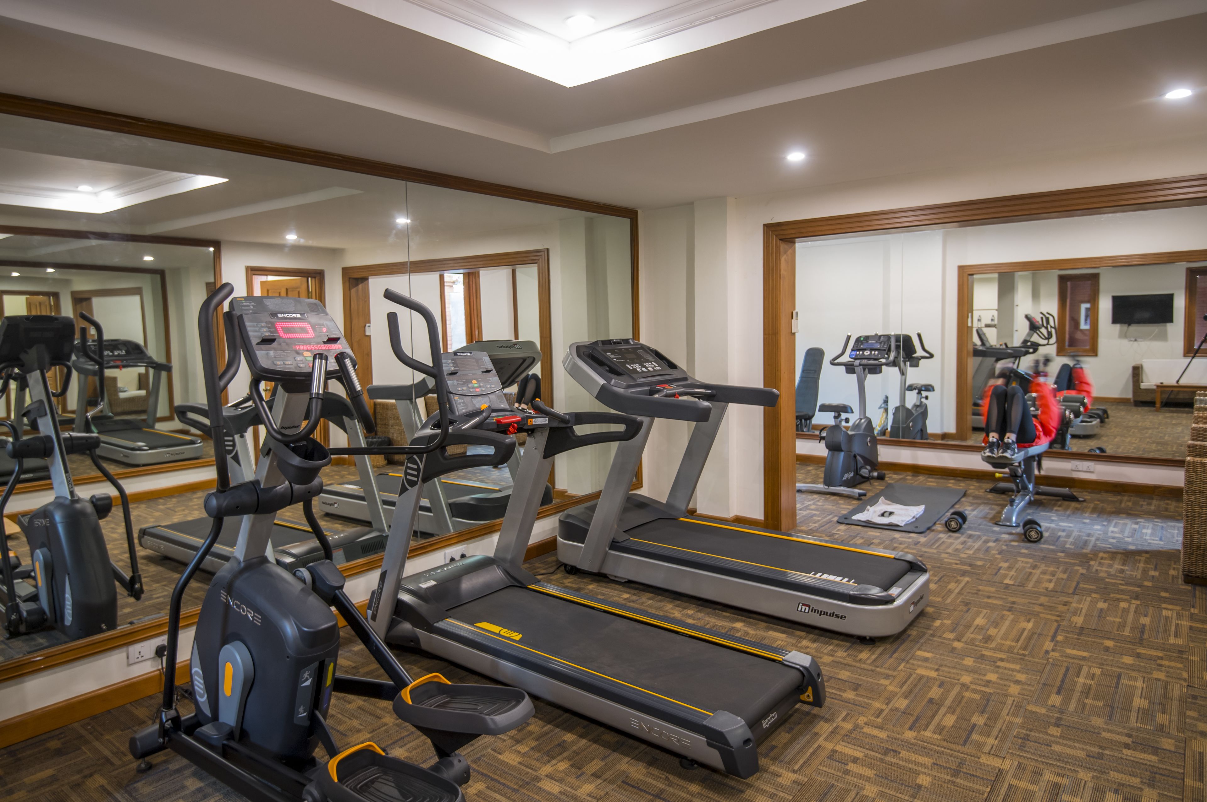 A gym with treadmills, an elliptical, and a stationary bike.