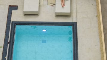 Una piscina al aire libre, tumbonas