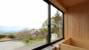 A room with a large window offering a view of a garden and distant landscape. - Yakushidaira Akanejyuku (Matsumoto)