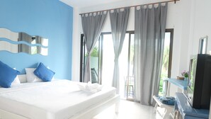 A bedroom with a bed, a TV, and a balcony with curtains. - Pranburi Delight Resort (Sam Roi Yot)