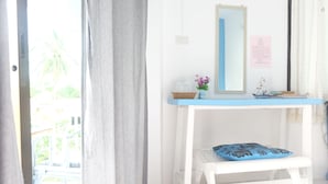 A room with a white desk, a blue cushion, and a small shelf with decorative items. - Pranburi Delight Resort (Sam Roi Yot)