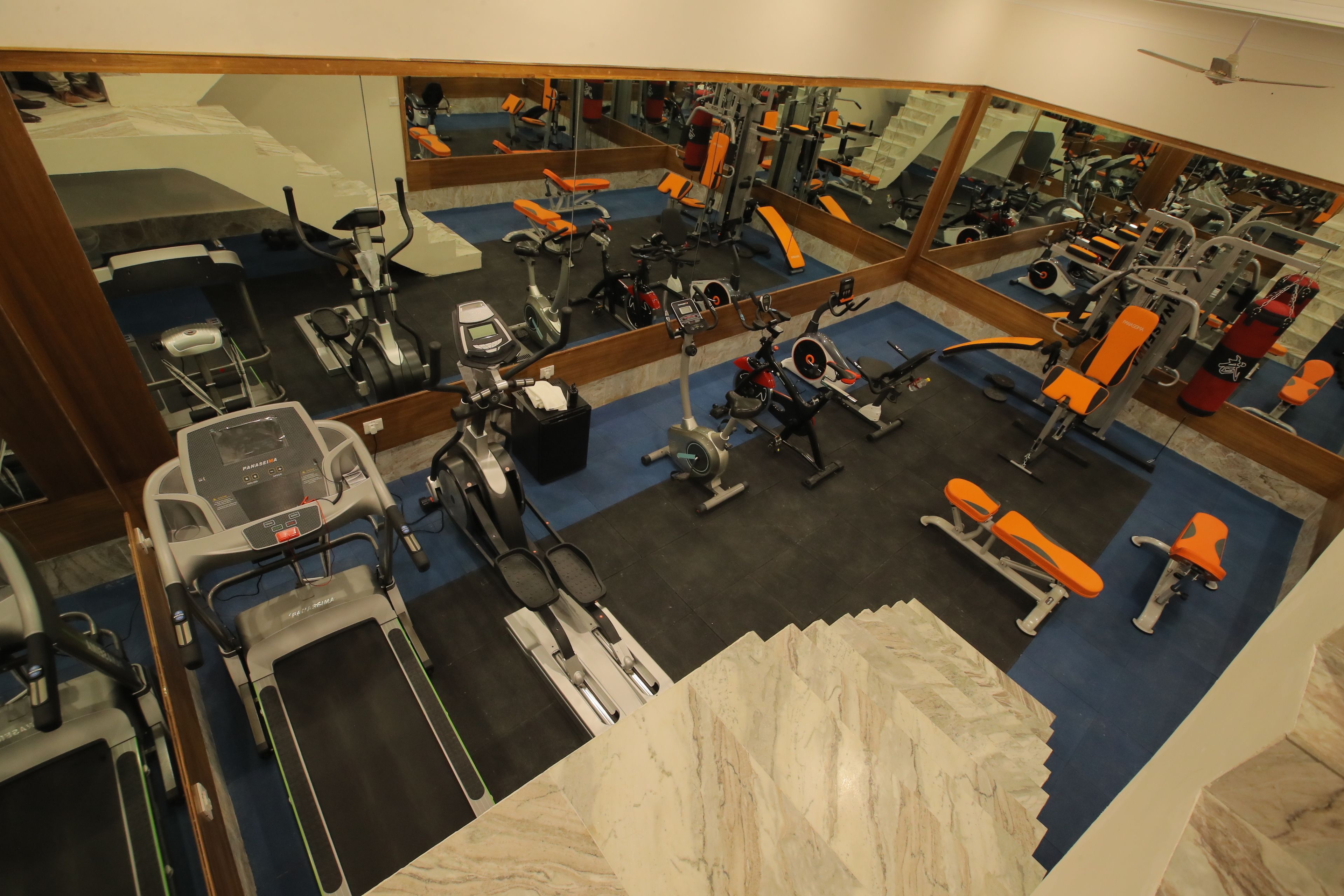 A gym with various exercise equipment, including treadmills, stationary bikes, and weight machines.