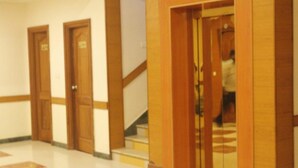 Un pasillo de hotel con puertas de madera y una escalera.