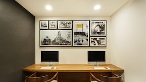 A conference room with a wooden table, two monitors, and framed pictures on the wall. - Ginger Hotel Lucknow (Lucknow)