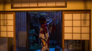 Um quarto japonês tradicional com portas deslizantes que dão para um jardim.