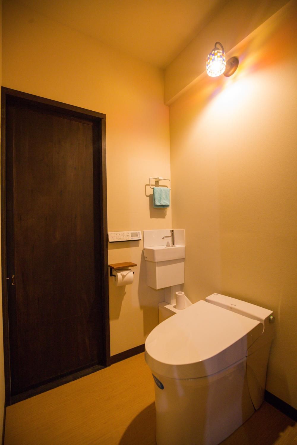A bathroom with a toilet, a sink, and a towel rack.