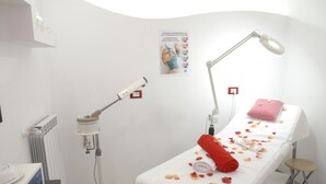 A clinical setting with medical equipment, a treatment bed, and a poster on the wall. - Hotel Supersonik (Acri)