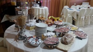 A buffet table with various food items including fruits, pastries, and deli meats. - Hotel Supersonik (Acri)