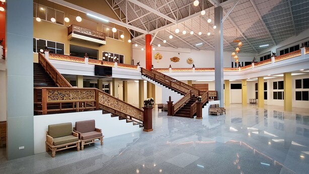 A spacious atrium with a central staircase, multiple balconies, and a polished floor. - Phuphaphung Resort (Suan Phueng)