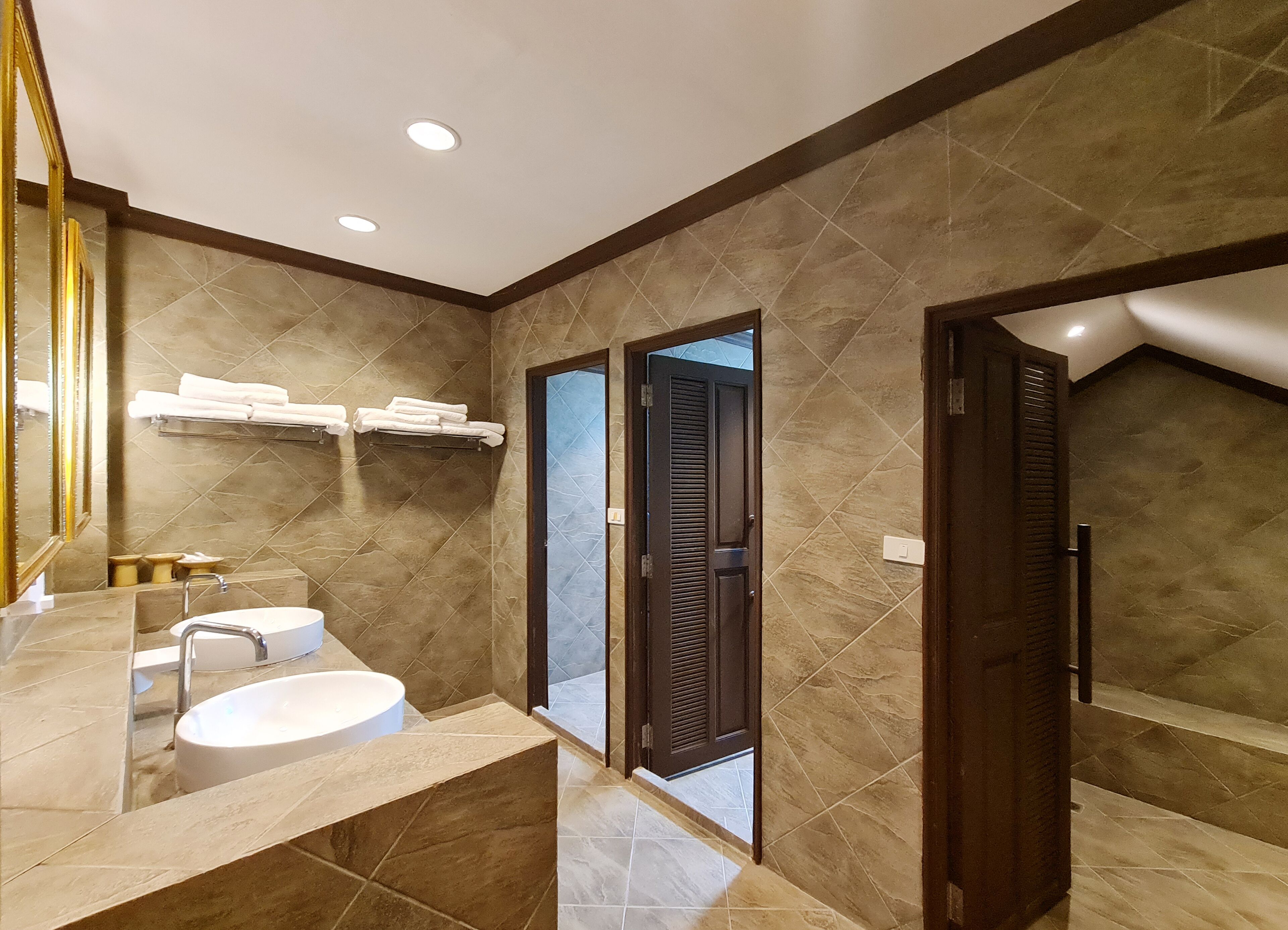 Un baño moderno con un espejo grande, un lavamanos y una zona de ducha.
