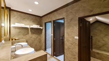 Un baño moderno con un espejo grande, un lavamanos y una zona de ducha.