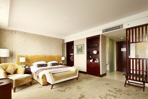 A hotel room with a large bed, a chair, a desk, and a wardrobe. - Zhenbao Holiday Hotel Nanjing Yuhua (Nanjing)