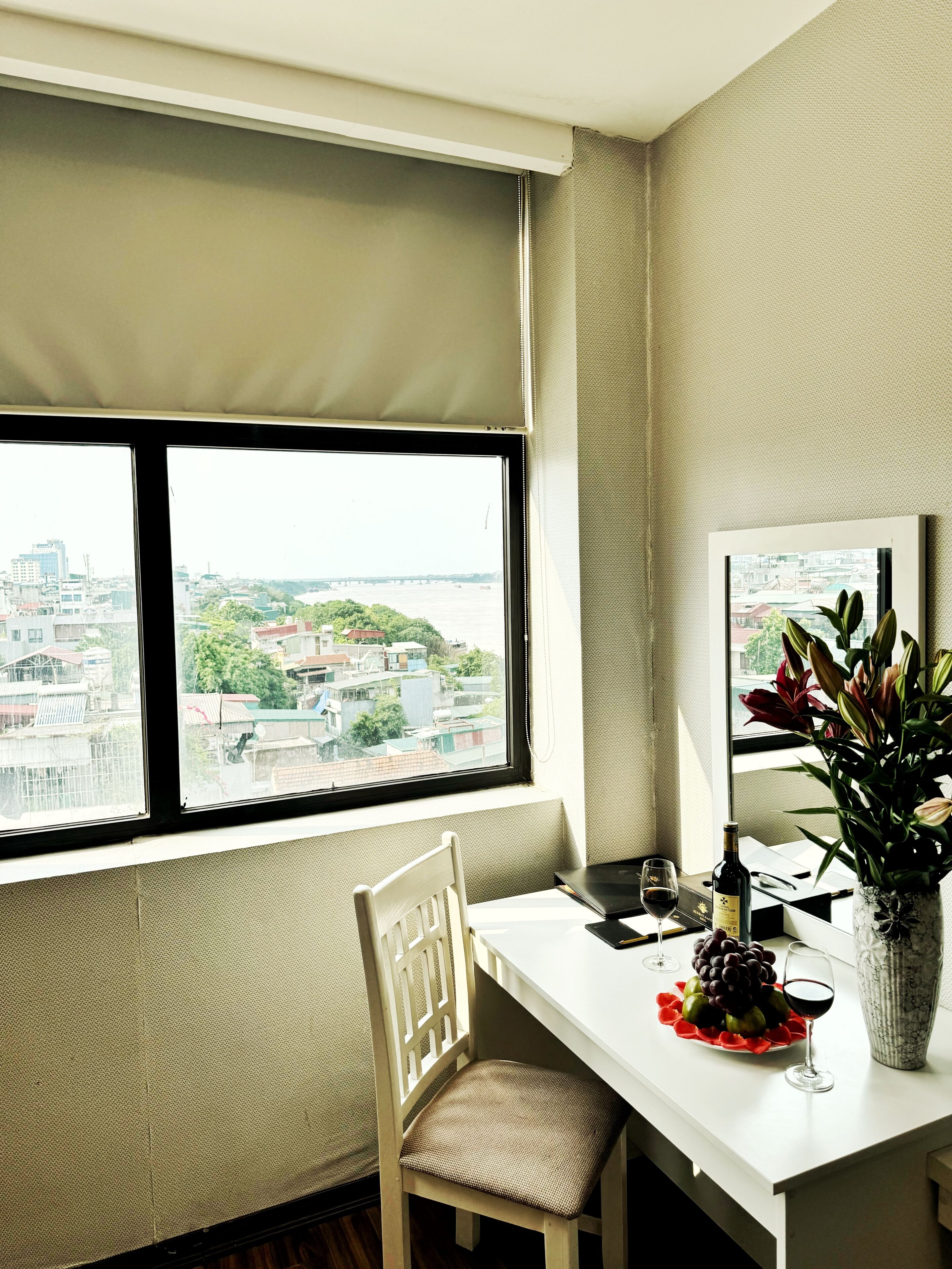 A dining area with a table, chair, and a window offering a city view.