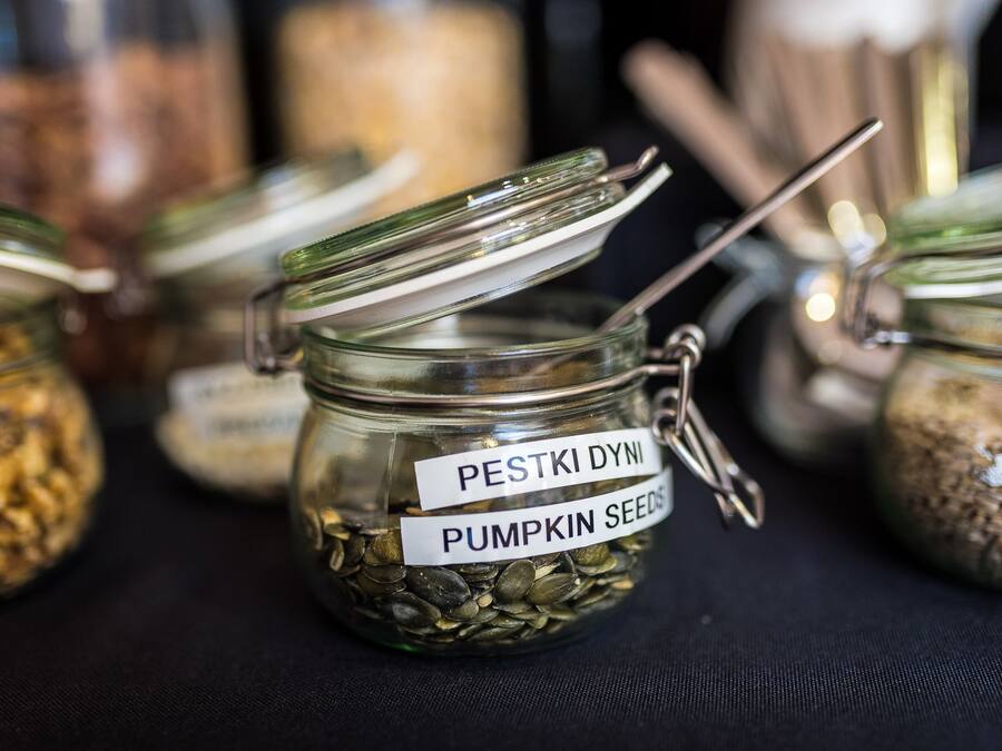 A jar labeled "PESTKI DYNI" containing pumpkin seeds.