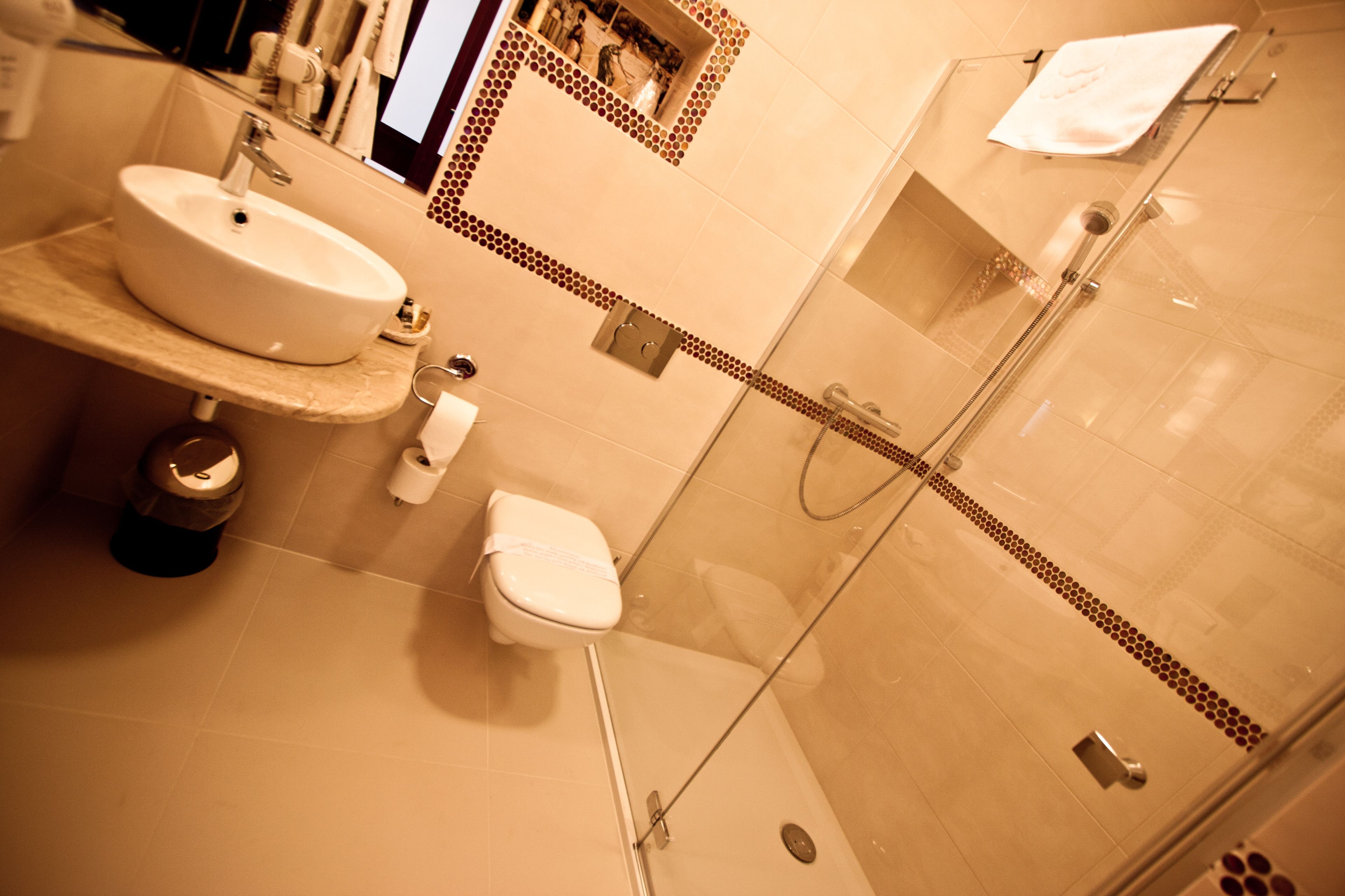 Une salle de bain équipée d’un lavabo, de toilettes et d’une douche à parois de verre.