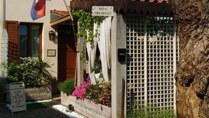 A building with a sign indicating a bed and breakfast, a flag, and a post office. - B&B Il Rustico (Turate)