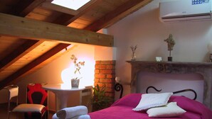 A cozy room with a bed, a chair, a small table, and a fireplace. - B&B Il Rustico (Turate)