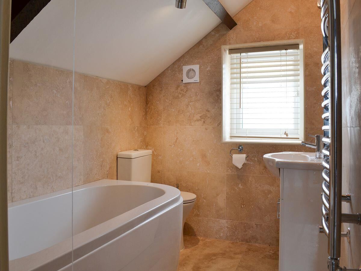A bathroom with a bathtub, toilet, and sink.