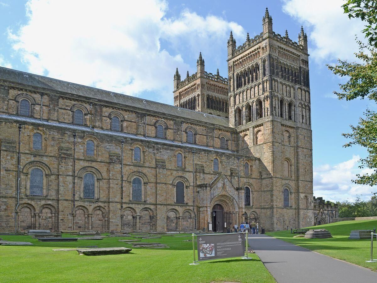 A large historic building with a prominent tower and arched windows.