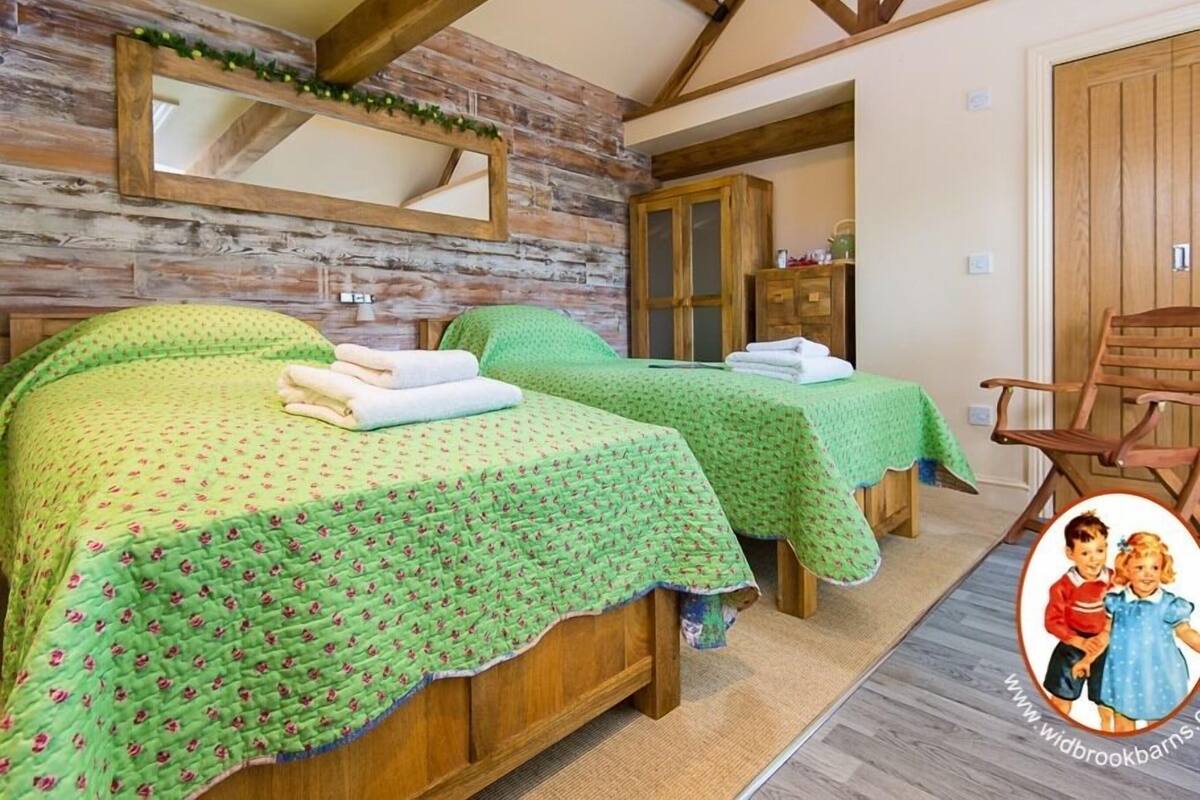 Een kamer met twee houten bedden, een houten garderobe, een spiegel en een houten stoel.