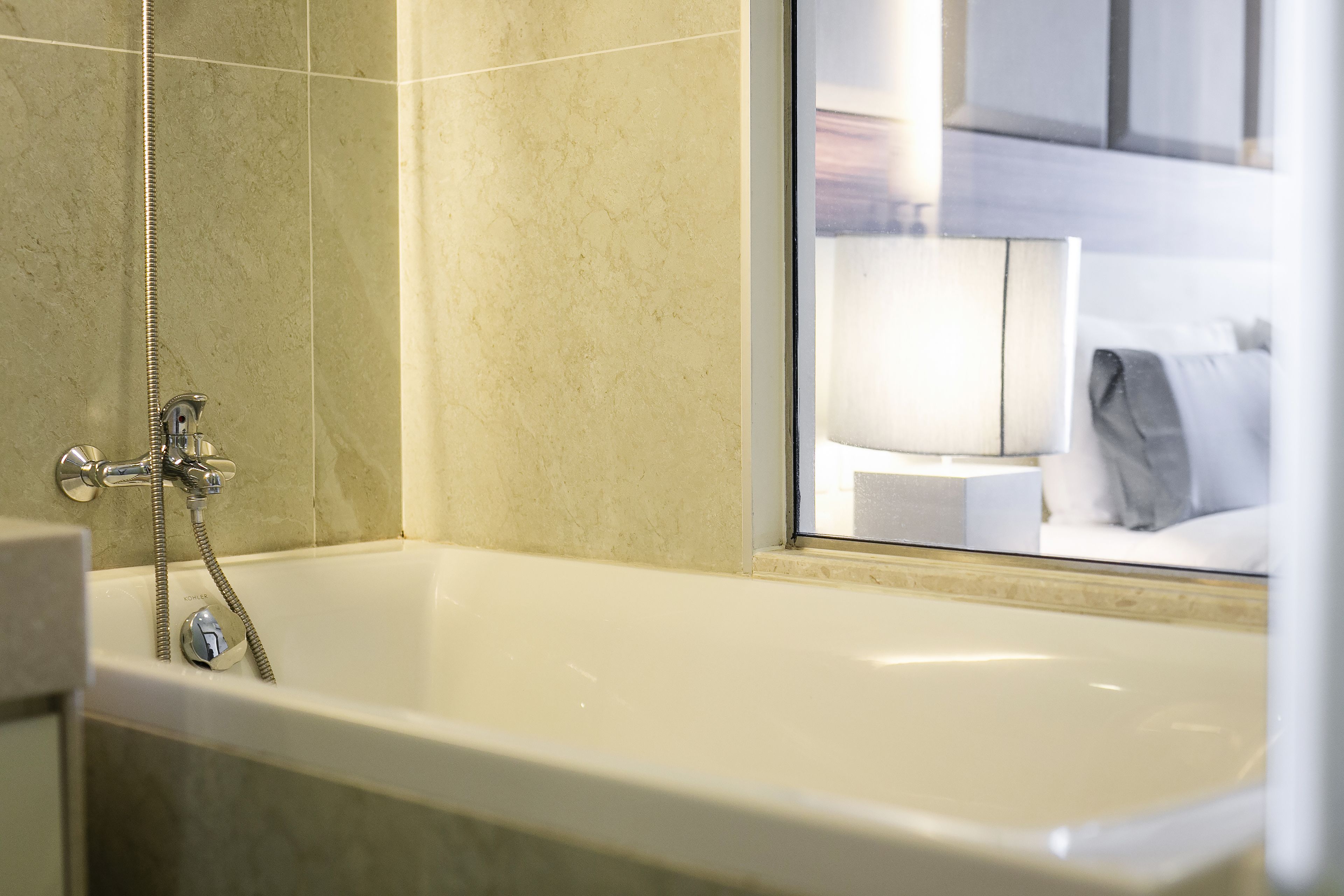 A modern bathroom with a bathtub, a shower, and a glass-enclosed window.