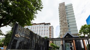 The entrance to the Astra Suites hotel with a prominent sign, a modern building in the background, and a clear sky. - Anta Residence Self-service Apartment (Chiang Mai)