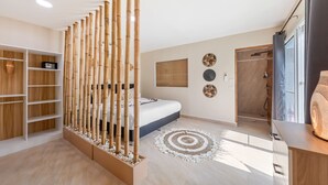 A modern bedroom with a bed, a bamboo screen, a walk-in closet, and a shower area. - Maya Resort (Koh Samui)