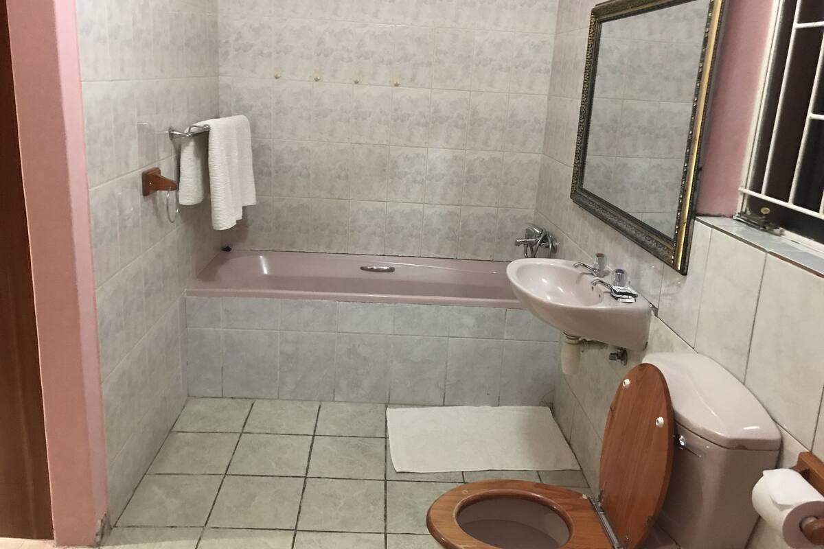 Ein kleines Badezimmer mit Badewanne, Waschbecken, Toilette und Spiegel.