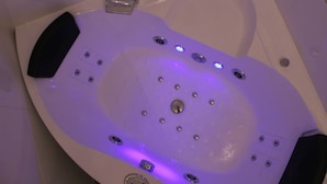 A bathtub with multiple jets, a handheld showerhead, and a control panel. - Apartmán Relax so saunou a jakuzzi (Namestovo)