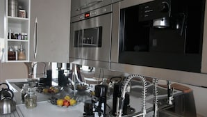 A modern kitchen with stainless steel appliances, including a refrigerator, oven, and coffee maker. - Apartmán Relax so saunou a jakuzzi (Namestovo)