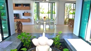A modern interior with a central water feature, surrounded by potted plants. - Baan Bua Nai Harn 3 bedrooms Villa (Rawai)