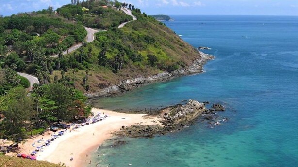 A coastal landscape with a winding road, a sandy beach, and clear turquoise waters. - Baan Bua Nai Harn 3 bedrooms Villa (Rawai)