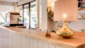 Una zona de bar con mostrador de madera, una lámpara de bronce y una campana.