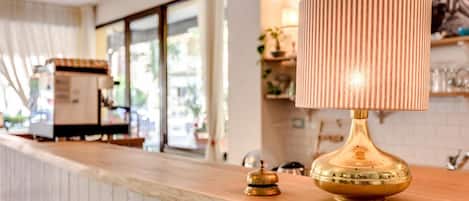 A bar area with a wooden counter, a brass lamp, and a bell.