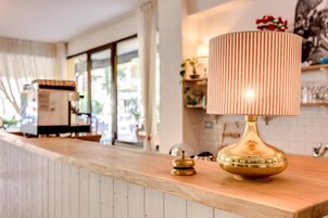 Un espace bar avec un comptoir en bois, une lampe en laiton et une cloche.