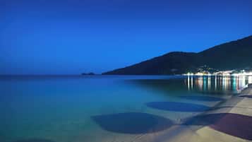 Á ströndinni, sólbekkir, sólhlífar, róðrarbátar