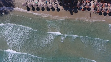 Rannalla, aurinkotuoleja, aurinkovarjoja, soutumahdollisuus