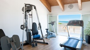 Ein Heimfitnessraum mit Laufband, Crosstrainer und Kraftmaschine.