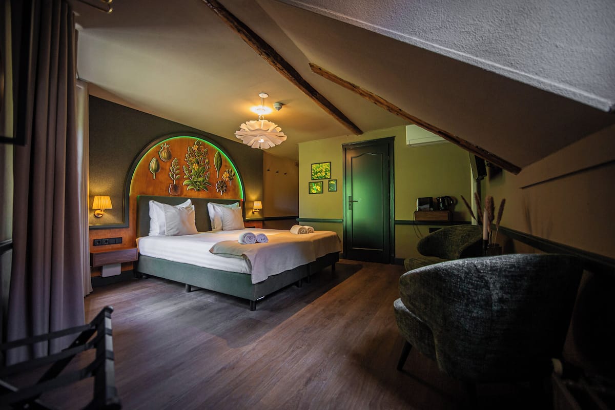 Une chambre d’hôtel avec un lit, des lampes de chevet, une chaise et une porte.