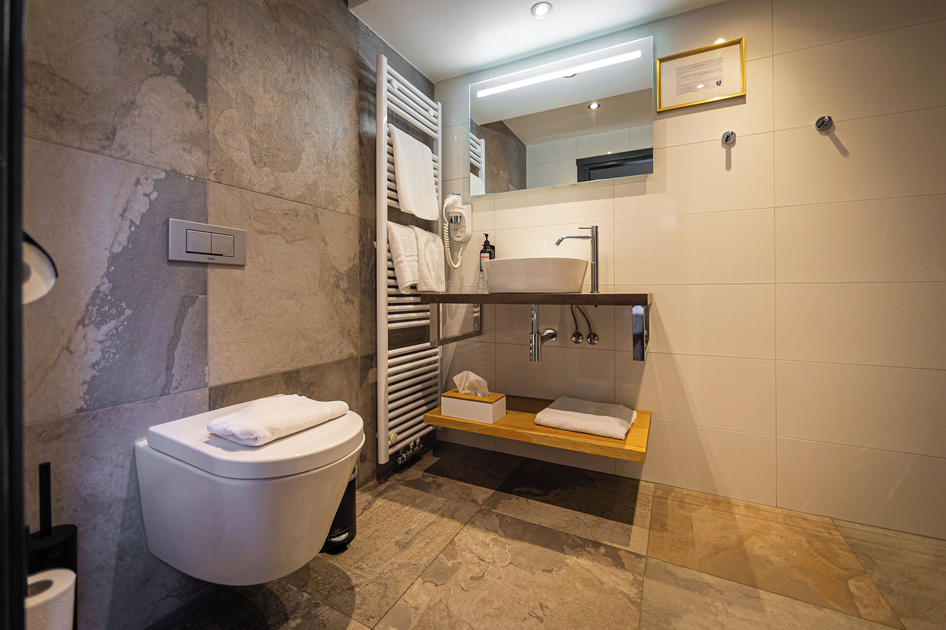 Un baño moderno con inodoro, lavabo y zona de ducha.